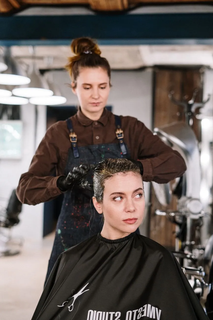 Estilista trabajando el color en el cabello de una clienta