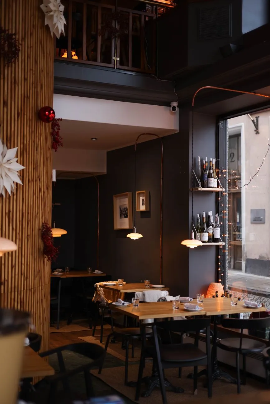 Interior de restaurante con luz cálida y las mesas puestas